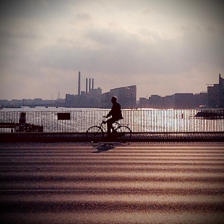 Cyclist riding on bridge over Nyhavn River